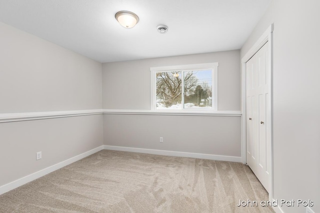 unfurnished bedroom featuring baseboards, carpet floors, and a closet