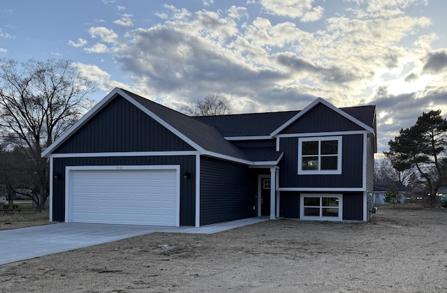 split level home featuring concrete driveway and an attached garage