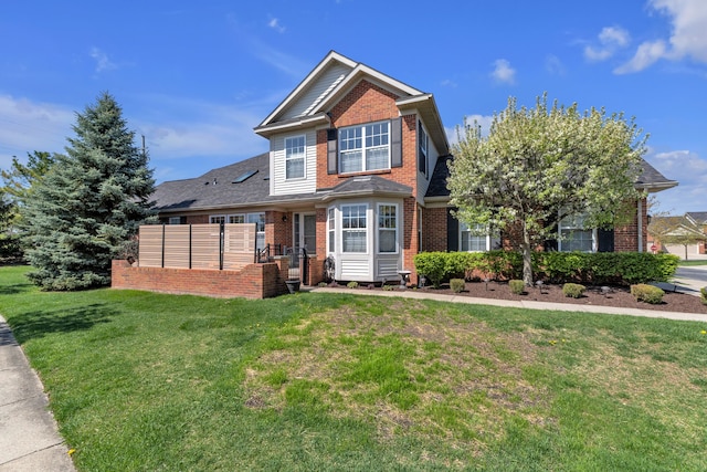 traditional-style house with a front lawn and brick siding