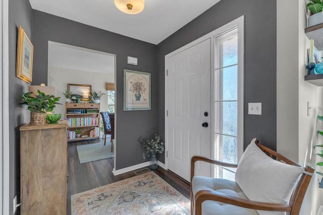 entryway featuring baseboards, visible vents, and dark wood-type flooring