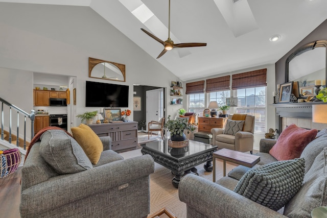 living area featuring stairs, ceiling fan, high vaulted ceiling, recessed lighting, and a skylight