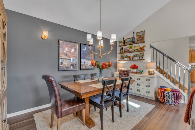 dining space featuring a notable chandelier, dark wood finished floors, stairs, baseboards, and lofted ceiling