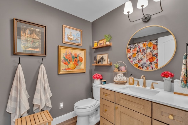 bathroom featuring vanity, baseboards, toilet, and wood finished floors