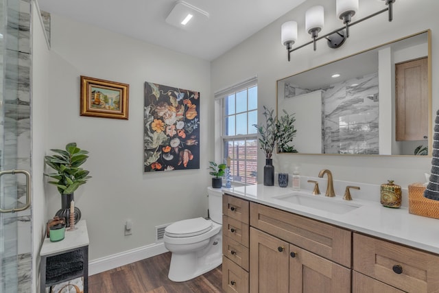 full bath featuring toilet, a shower with door, wood finished floors, and vanity