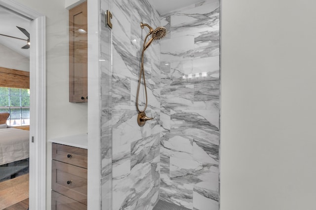 ensuite bathroom featuring connected bathroom, a ceiling fan, and a marble finish shower