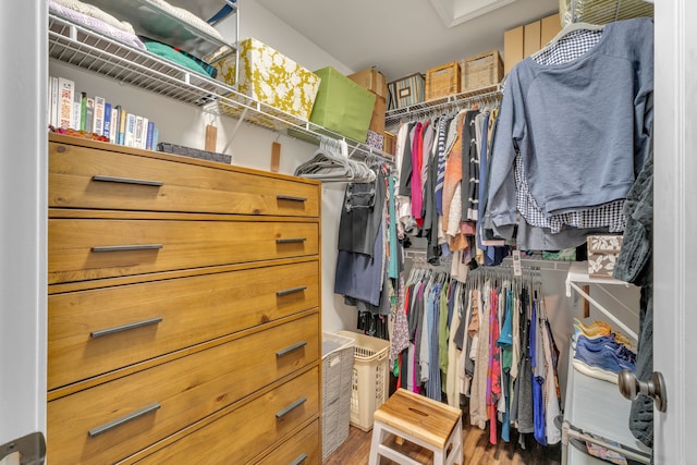 spacious closet featuring wood finished floors and attic access