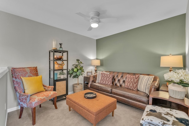 living room with baseboards, a ceiling fan, and light carpet