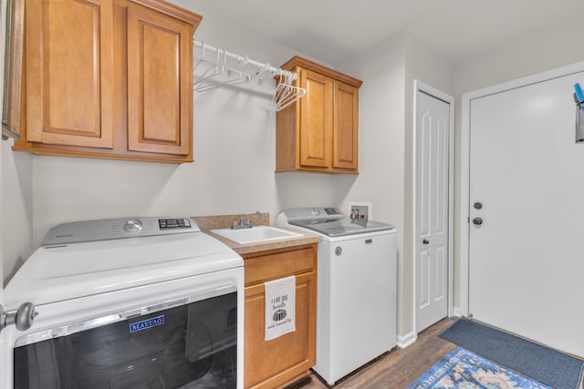 clothes washing area featuring cabinet space, dark wood-style flooring, a sink, and washer and dryer