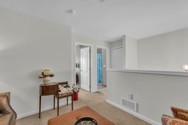 living area with baseboards, carpet, and visible vents