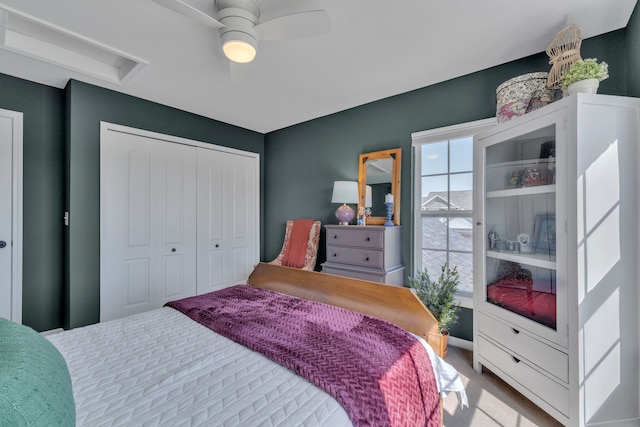 bedroom with carpet flooring, a ceiling fan, attic access, and a closet