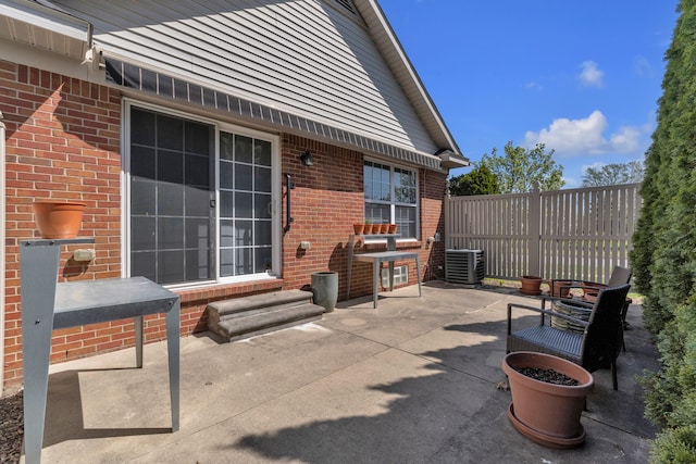 view of patio featuring entry steps, fence, and central AC