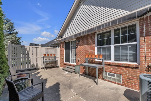 view of patio with entry steps, fence, and central AC unit
