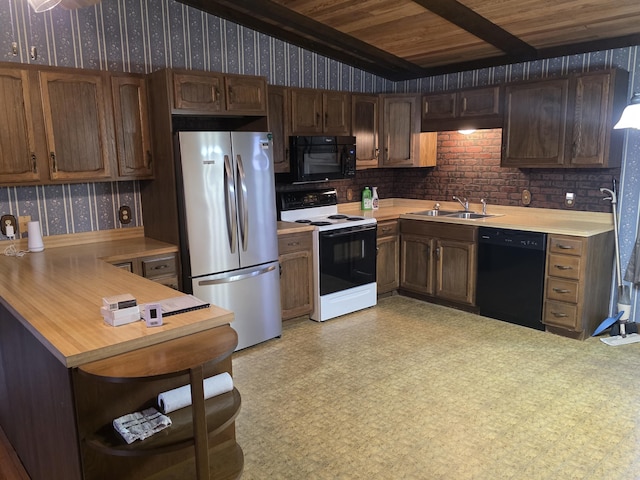 kitchen featuring wallpapered walls, open shelves, light countertops, black appliances, and a sink