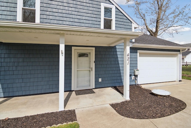 entrance to property featuring a garage, driveway, and covered porch