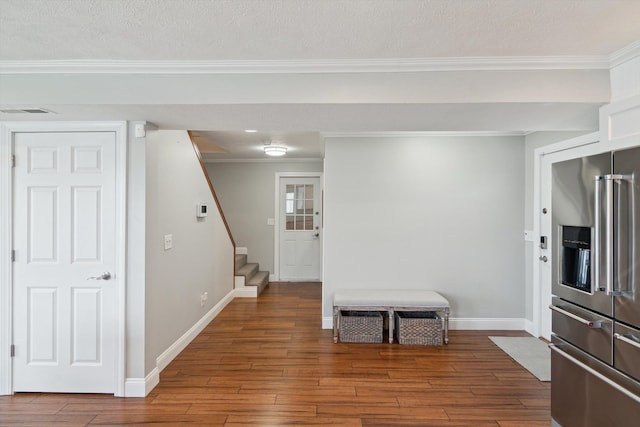 interior space with visible vents, ornamental molding, high end fridge, baseboards, and dark wood-style floors