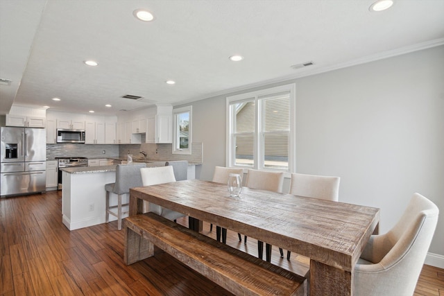 dining space featuring crown molding, recessed lighting, dark wood finished floors, and visible vents