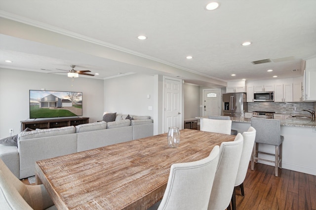 dining room with dark wood finished floors, recessed lighting, a ceiling fan, visible vents, and ornamental molding