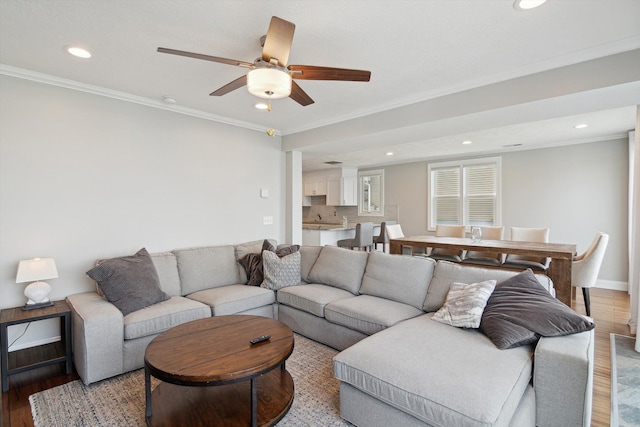 living area with light wood-style floors, recessed lighting, ceiling fan, and ornamental molding