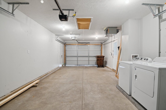garage featuring baseboards, a garage door opener, and independent washer and dryer