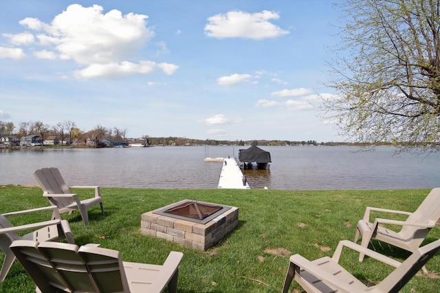 view of dock with a lawn, a water view, and an outdoor fire pit