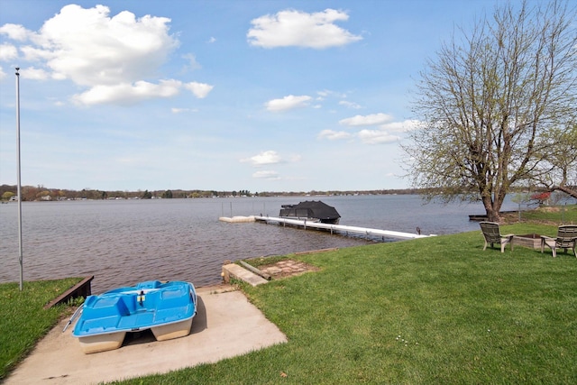 dock area featuring a lawn, a water view, and an outdoor fire pit