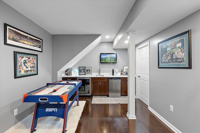 rec room featuring recessed lighting, wet bar, baseboards, and dark wood-type flooring