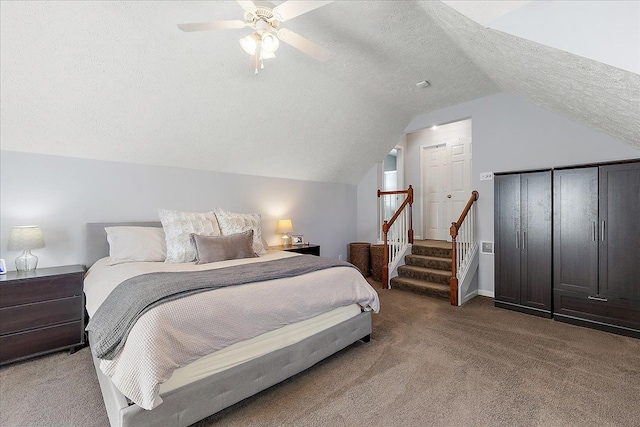 bedroom featuring ceiling fan, a textured ceiling, lofted ceiling, and light colored carpet