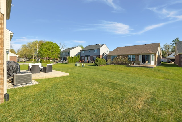 view of yard featuring central AC, a patio area, and a residential view