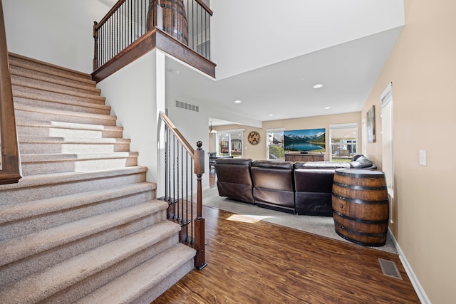 staircase with recessed lighting, visible vents, wood finished floors, and baseboards