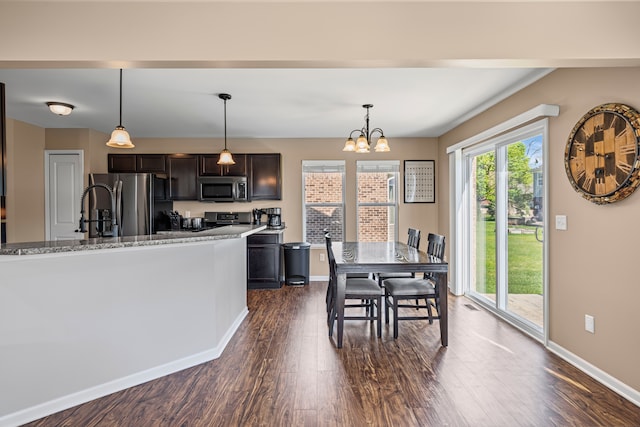 dining space featuring an inviting chandelier, baseboards, and dark wood finished floors