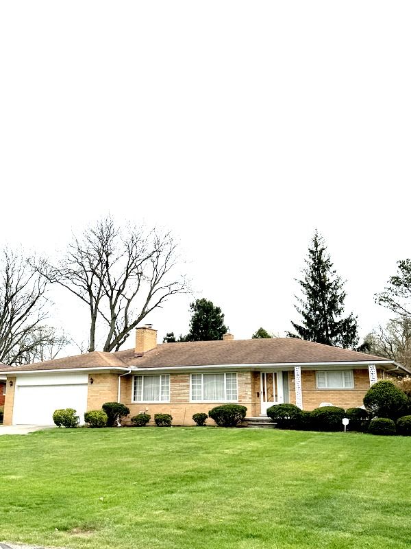 18337 Greenwald Dr, Southfield, MI 48075 - ranch-style home featuring a front yard, a chimney, brick siding, concrete driveway, and an attached garage