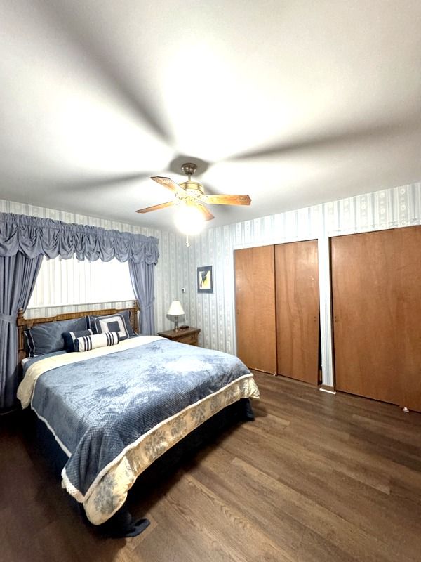 18337 Greenwald Dr, Southfield, MI 48075 - bedroom with two closets, ceiling fan, and wood finished floors