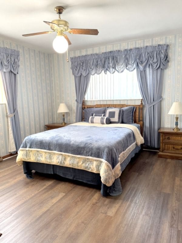 18337 Greenwald Dr, Southfield, MI 48075 - bedroom featuring ceiling fan, wood finished floors, and wallpapered walls