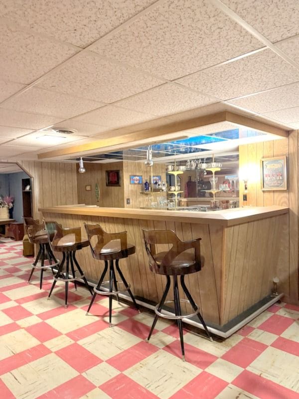 18337 Greenwald Dr, Southfield, MI 48075 - bar featuring tile patterned floors, a bar, a drop ceiling, and wood walls