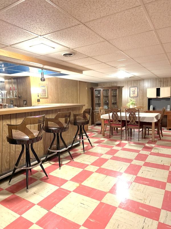 18337 Greenwald Dr, Southfield, MI 48075 - bar with tile patterned floors, wood walls, bar area, and a paneled ceiling