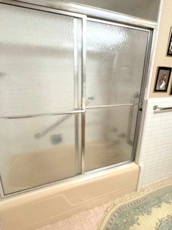 18337 Greenwald Dr, Southfield, MI 48075 - full bathroom with tile walls, tile patterned flooring, wainscoting, and shower / bath combination with glass door