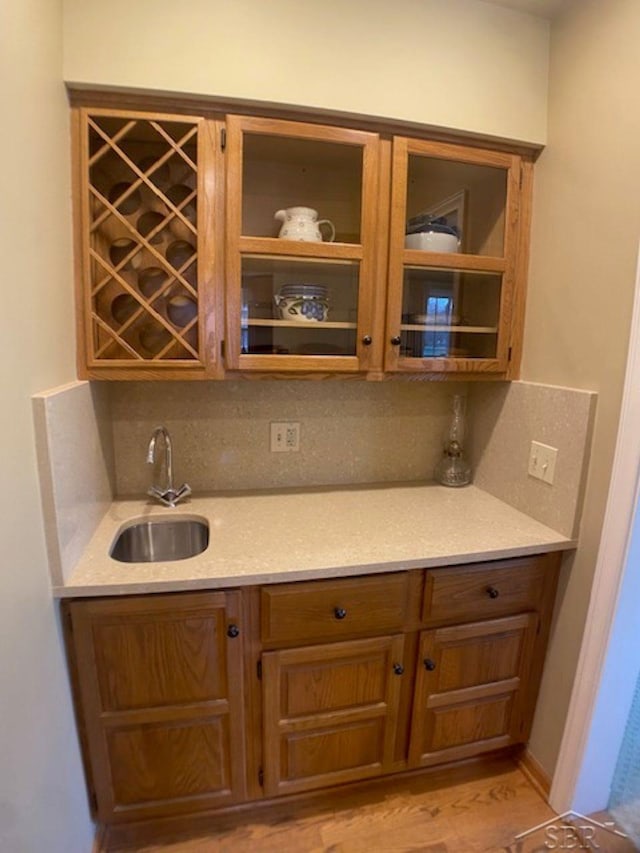 68 Davis Dr, Saginaw, MI 48602 - bar featuring wet bar, backsplash, light wood-style floors, and a sink