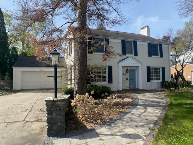 68 Davis Dr, Saginaw, MI 48602 - colonial house featuring driveway, a chimney, and stucco siding