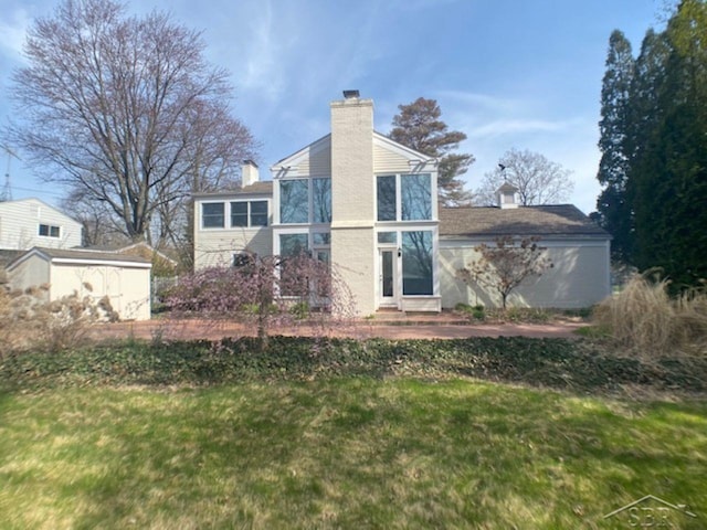 68 Davis Dr, Saginaw, MI 48602 - rear view of house featuring a chimney, entry steps, and a yard