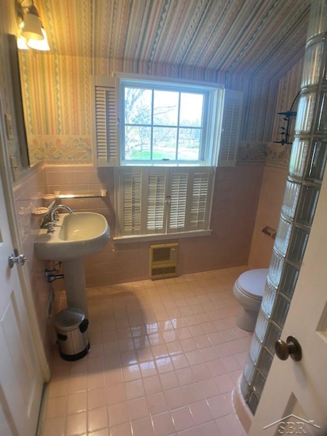 68 Davis Dr, Saginaw, MI 48602 - bathroom with heating unit, tile patterned floors, wallpapered walls, tile walls, and toilet