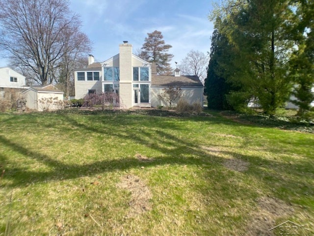 68 Davis Dr, Saginaw, MI 48602 - back of property featuring a chimney and a yard