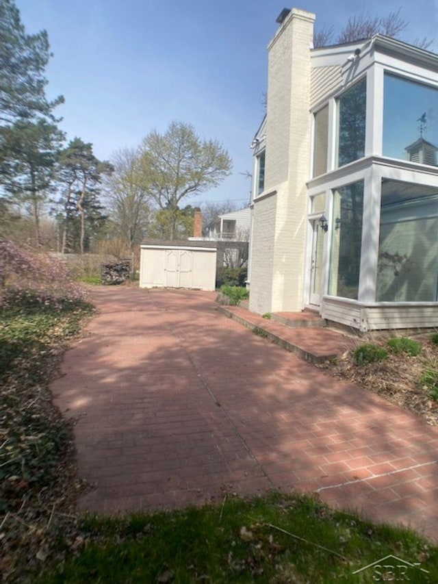 68 Davis Dr, Saginaw, MI 48602 - view of home's exterior with a chimney and a sunroom