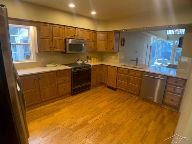 68 Davis Dr, Saginaw, MI 48602 - kitchen featuring a sink, stainless steel appliances, light wood-type flooring, recessed lighting, and brown cabinetry