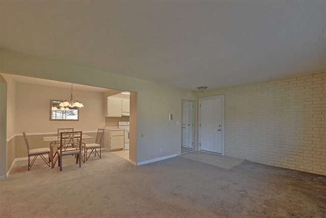 interior space with baseboards, brick wall, light colored carpet, and an inviting chandelier