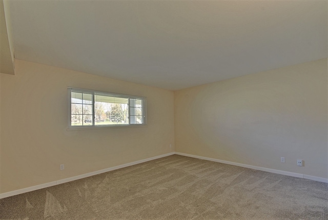 spare room featuring baseboards and light colored carpet