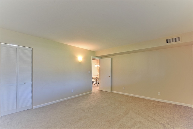 unfurnished bedroom featuring baseboards, light carpet, and visible vents
