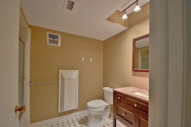 bathroom featuring an enclosed shower, vanity, toilet, and visible vents
