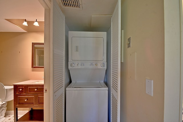 laundry room featuring visible vents, laundry area, and stacked washing maching and dryer