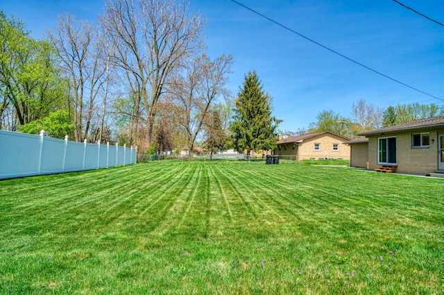 view of yard featuring fence and entry steps