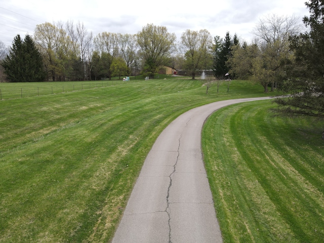 view of home's community featuring fence and a yard